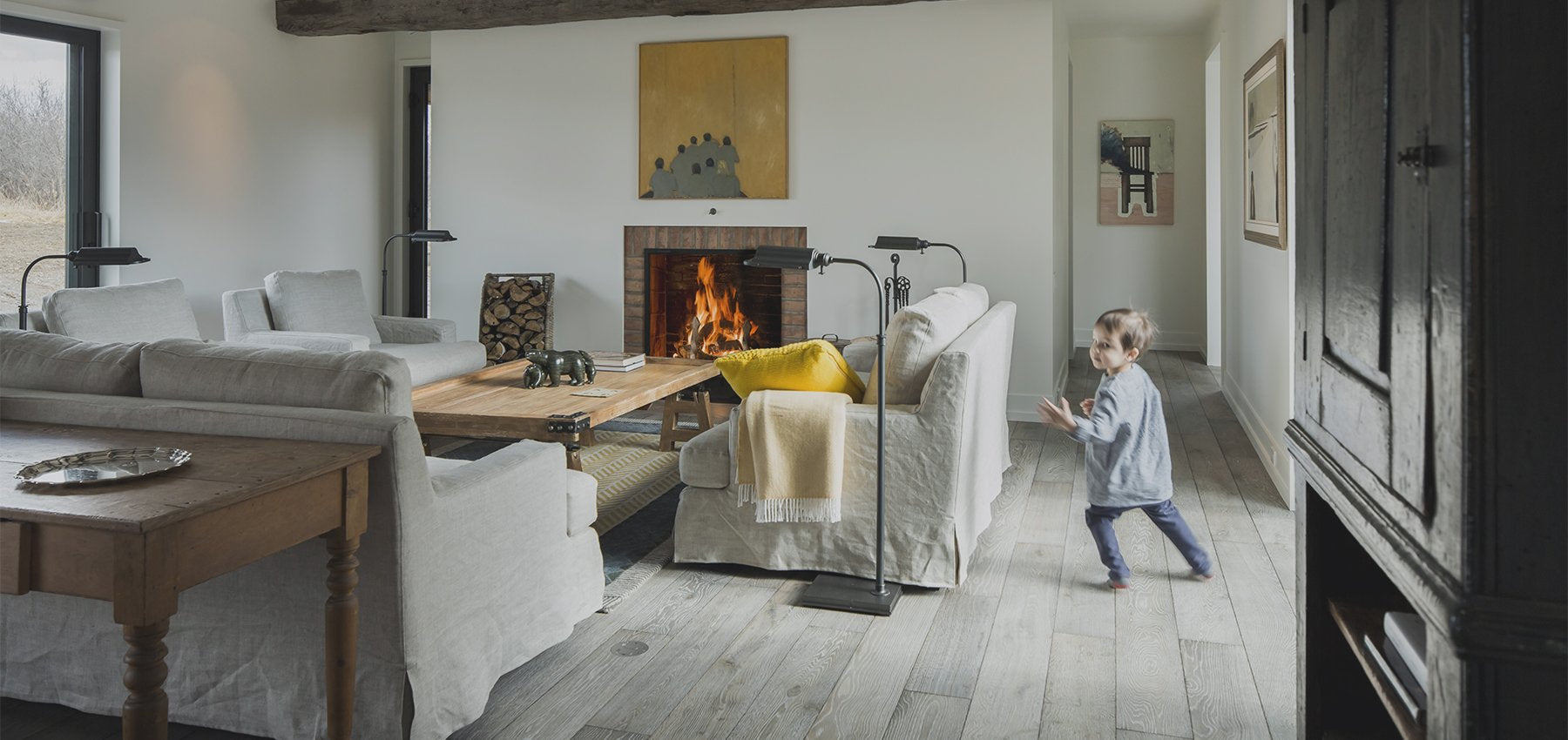 an interior view with midcentury modern furniture and northern wide wood planks on the floor