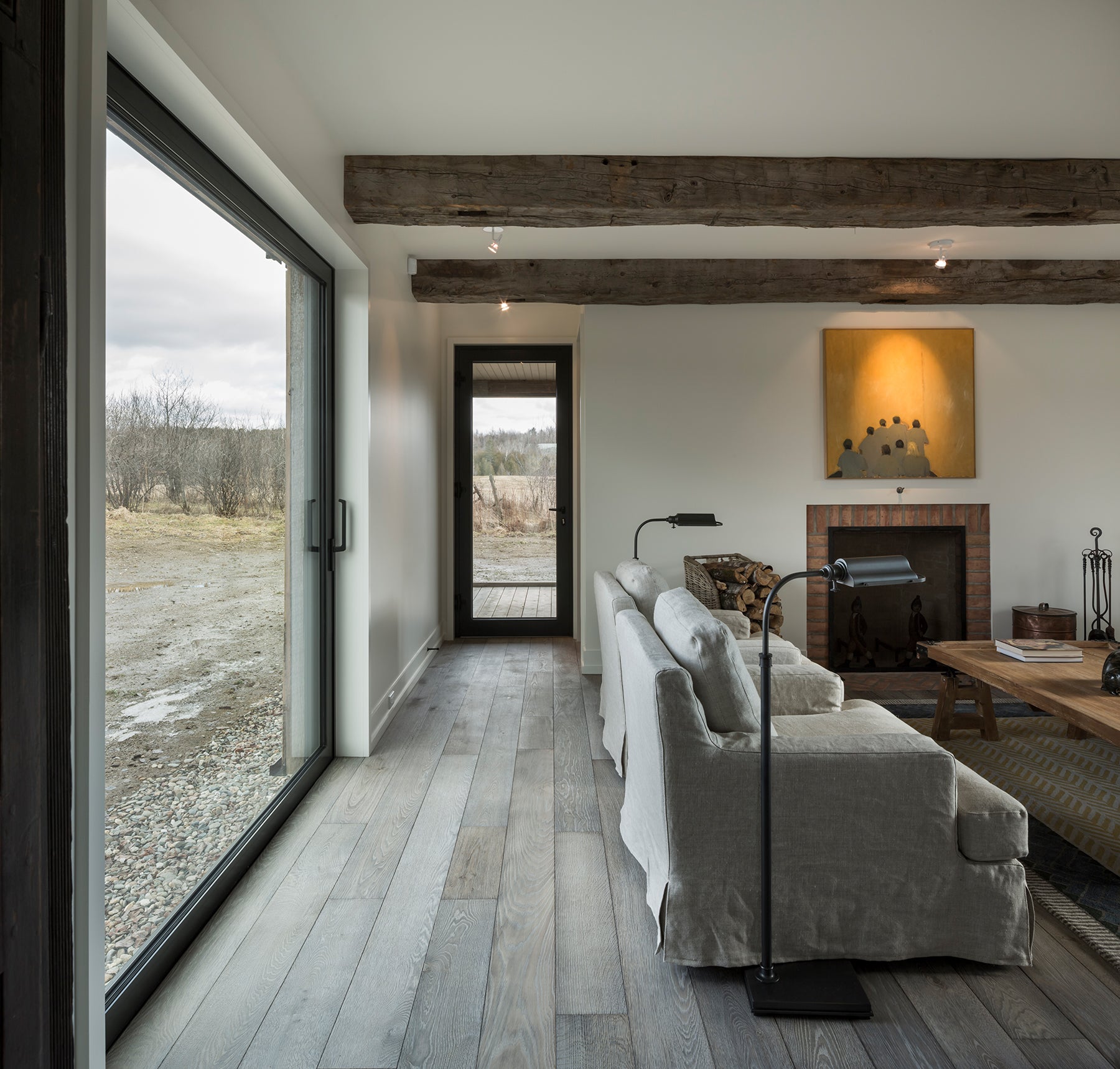 an interior view with midcentury modern furniture and northern wide wood planks on the floor