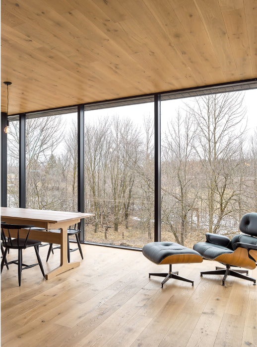 an interior view with midcentury modern furniture and northern wide wood planks on the floor